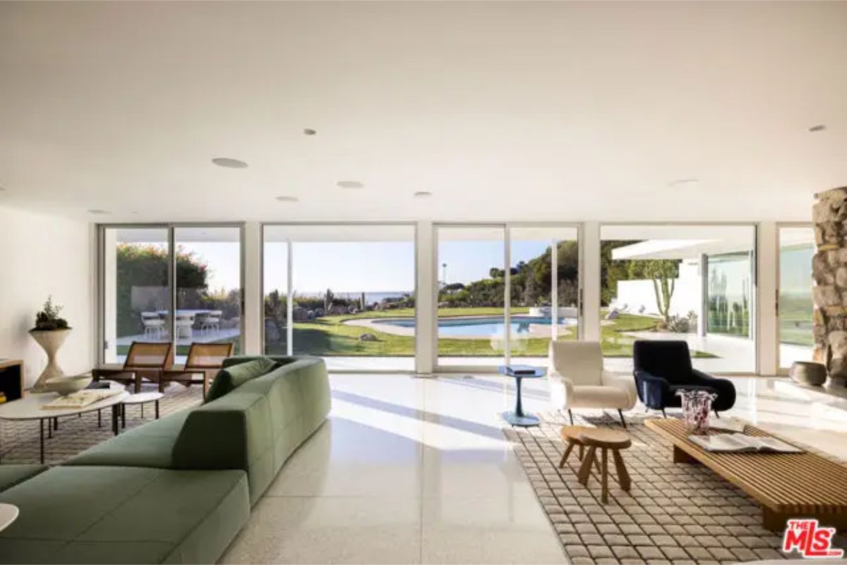 Spacious living room with floor-to-ceiling windows showcasing breathtaking outdoor views. 