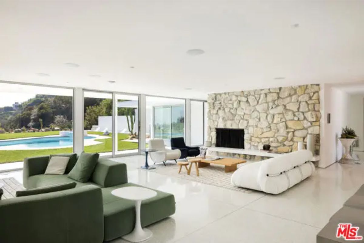 Cozy yet modern lounge area with a stone fireplace and seamless indoor-outdoor integration. 