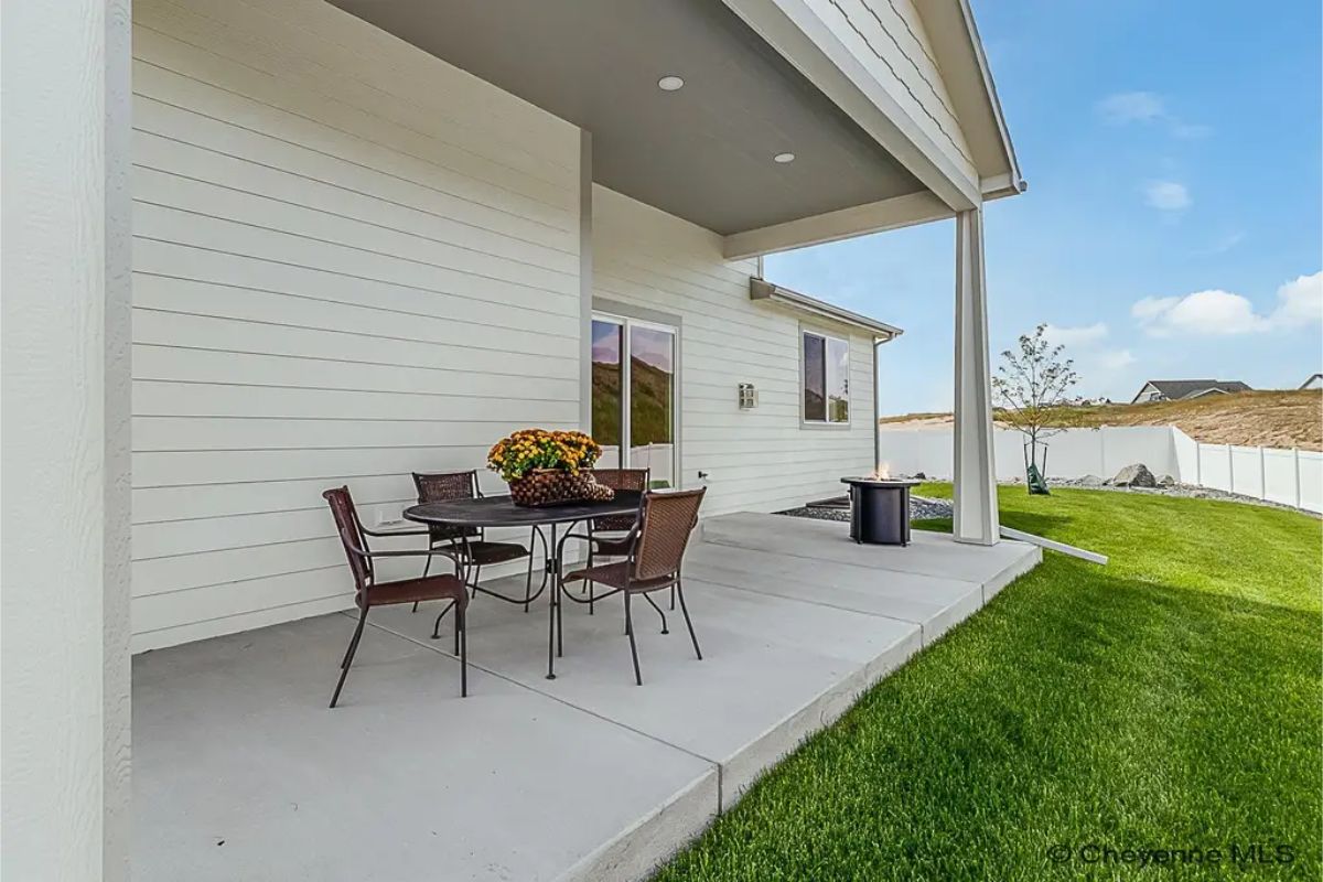 Concrete patio extends from the house and is partially covered.