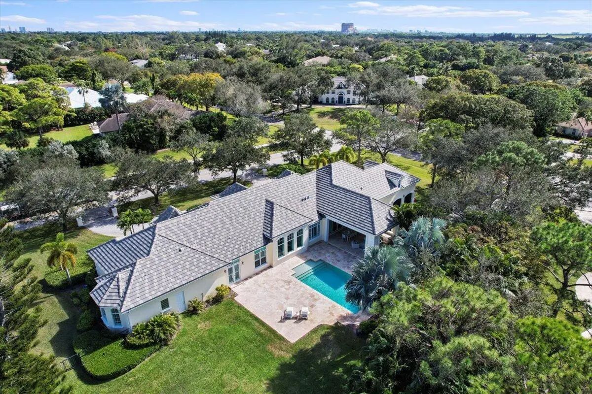 Sunlight filters through towering trees, wrapping this estate in a canopy of lush greenery and privacy.