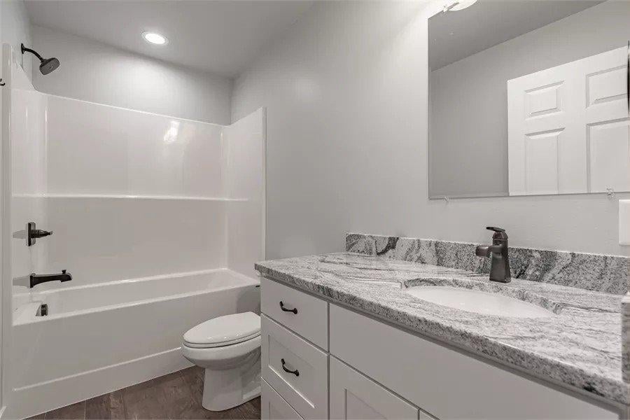 Simple Yet Elegant Bathroom with Granite Vanity and Dark Fixtures