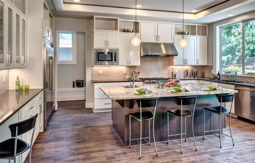 Notice the Bold Pendant Lights Above This Sleek Kitchen Island