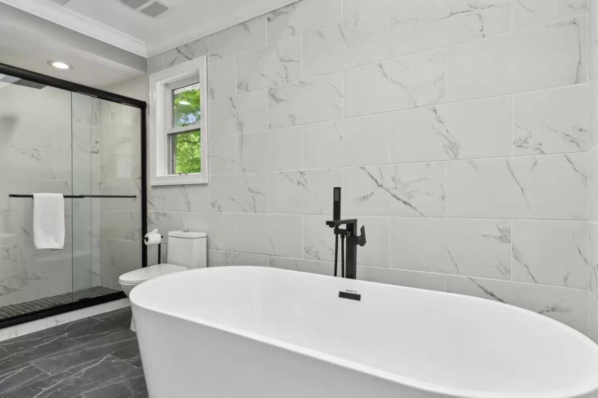 Check Out the Sleek Freestanding Tub Against Marble Walls