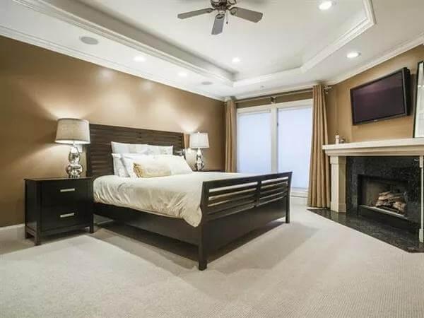 Relax in This Master Bedroom with Tray Ceiling and Fireplace
