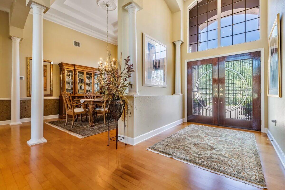 Elegant Entryway with Intricate Doors and a Peek into a Formal Dining Area