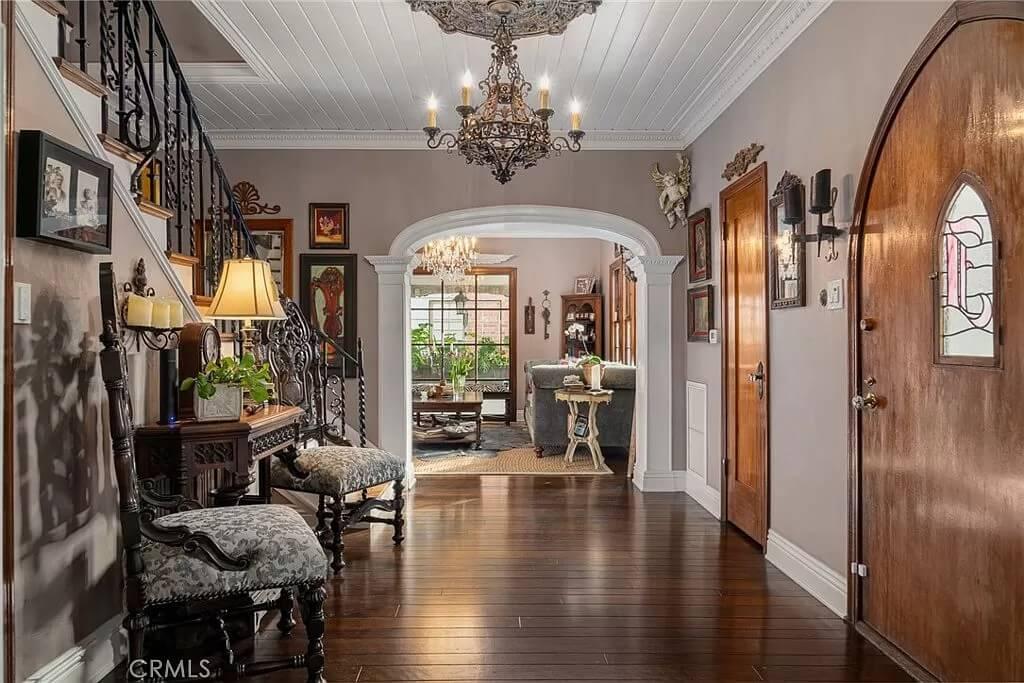 Step Into This Grand Entryway With Striking Ironwork and Chandelier
