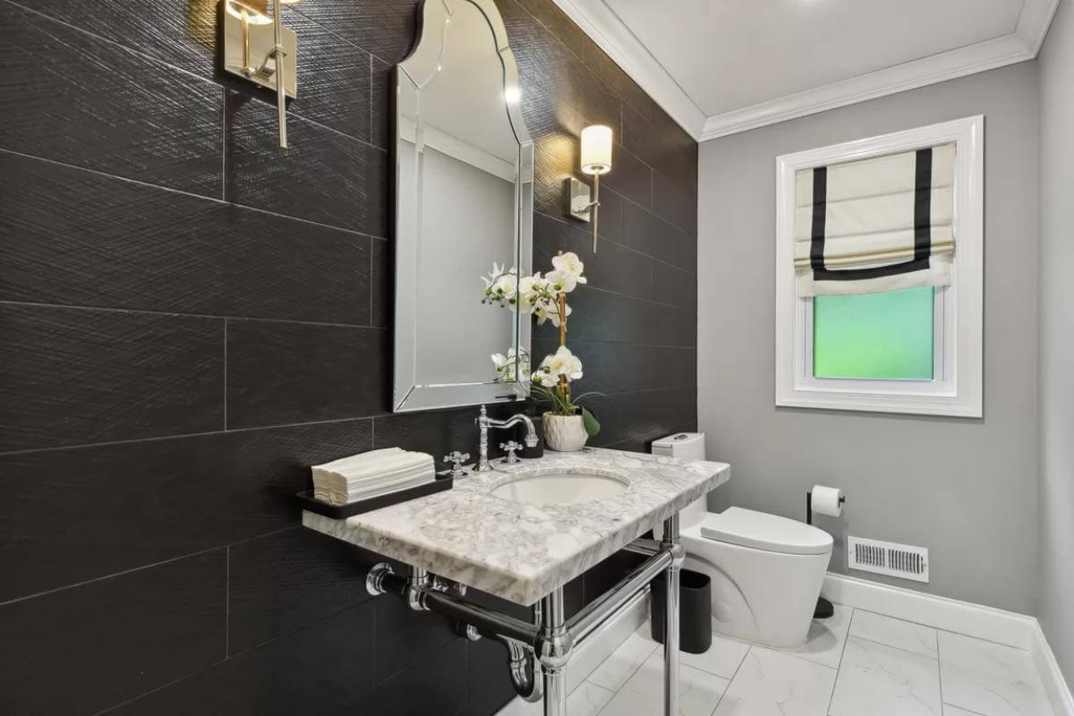 Elegant Powder Room with a Striking Mirror and Marble Sink