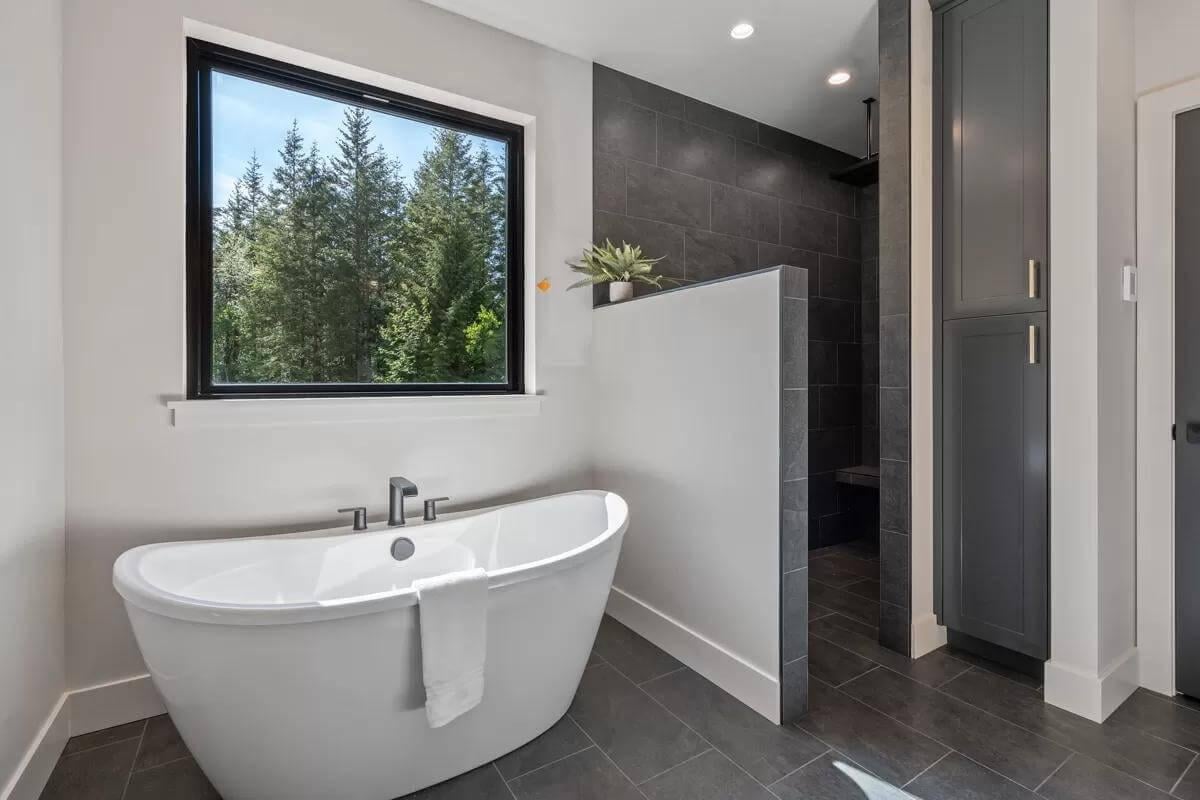 Take a Moment to Appreciate the Freestanding Tub Framing Forest Views