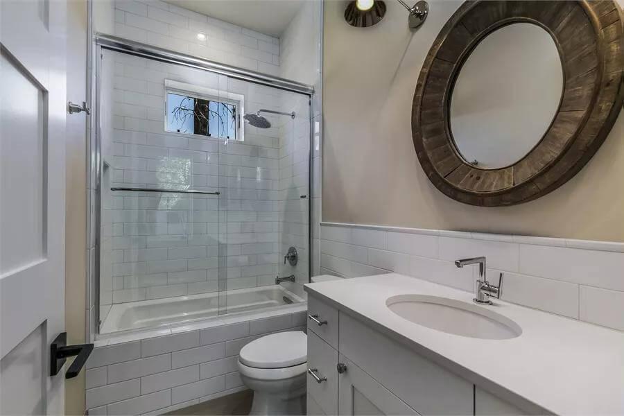 Round Wood-Framed Mirror Adds a Rustic Touch in This Sleek Bathroom