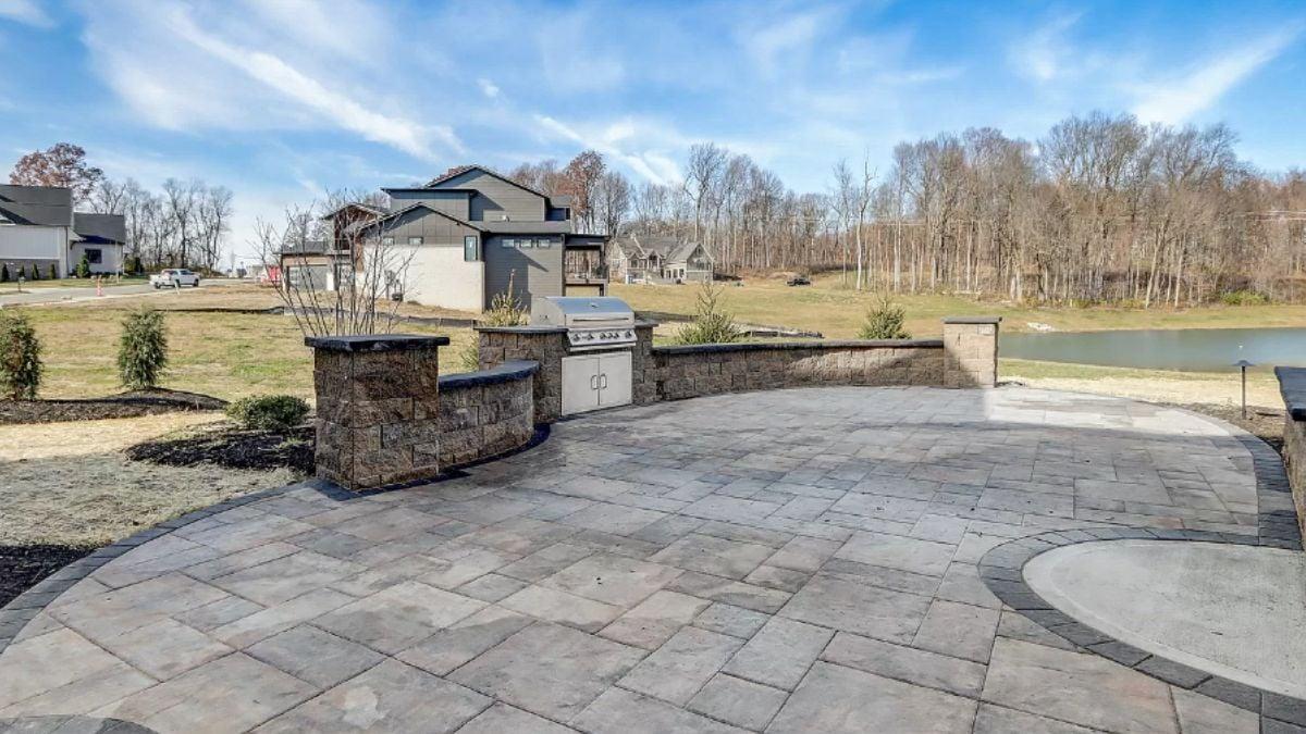 Check Out This Expansive Stone Patio with Built-In Grill