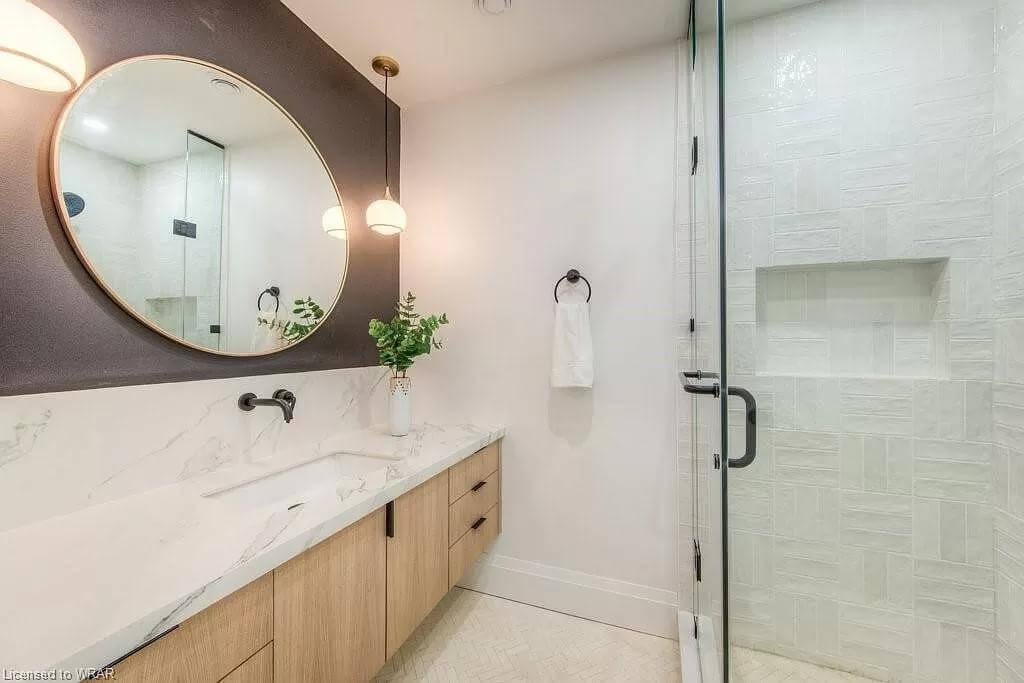 Check Out the Round Mirror and Marble Vanity in This Elegant Bathroom