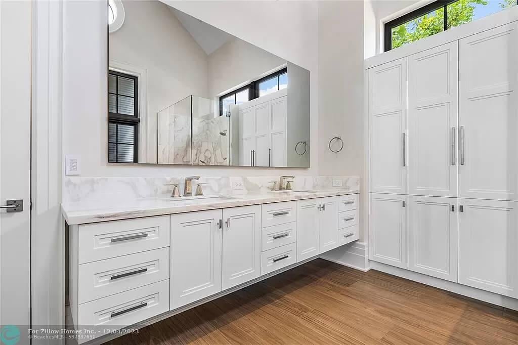 Admire the Tall Cabinets and Sleek Double Vanity in This Bright Bathroom