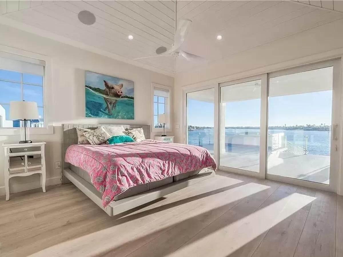 Vibrant Bedroom with Waterfront Balcony and Playful Artwork