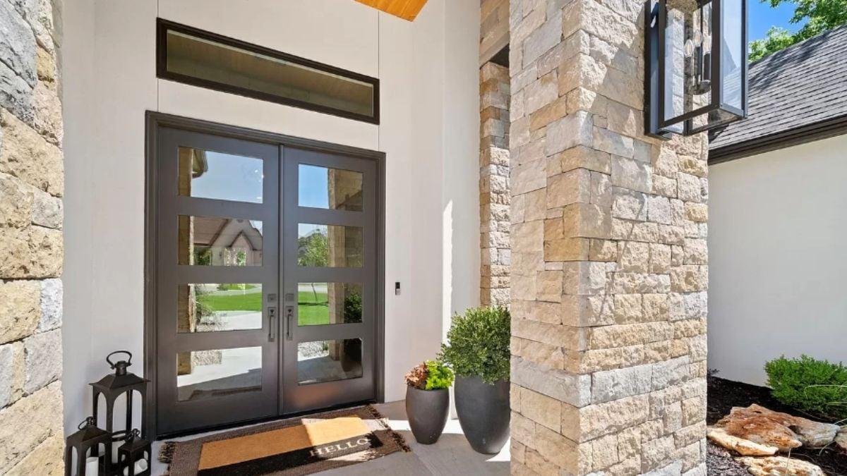Sophisticated Entryway with Dramatic Glass Doors and Stone Accents