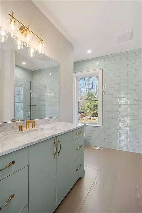 Chic Bathroom with Seafoam Cabinetry and Brass Accents
