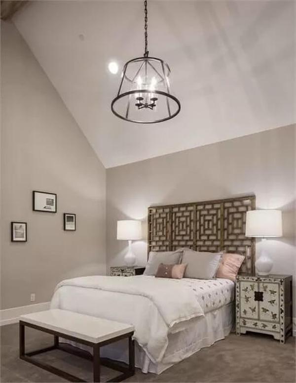 Engage with the Intricate Headboard and Vaulted Ceiling in This Bedroom