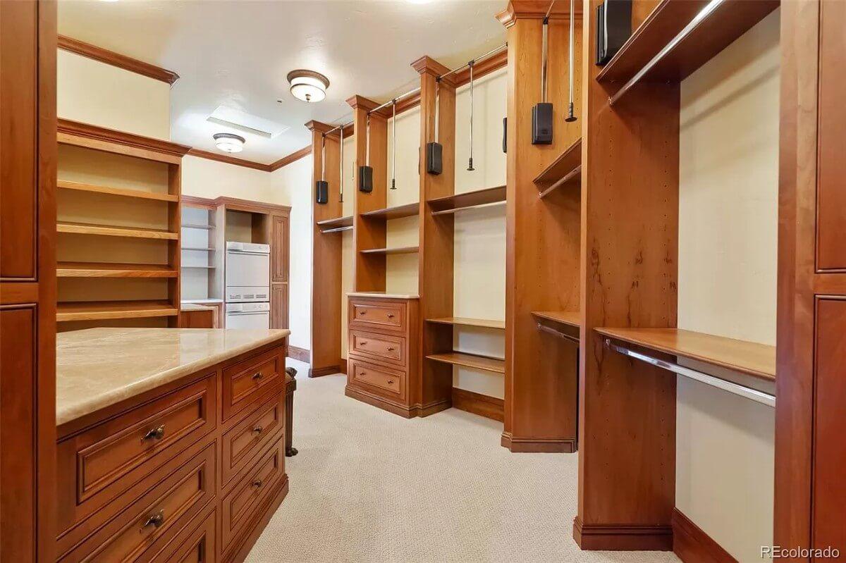 Step Inside This Generous Walk-In Closet with Rich Wood Finishes
