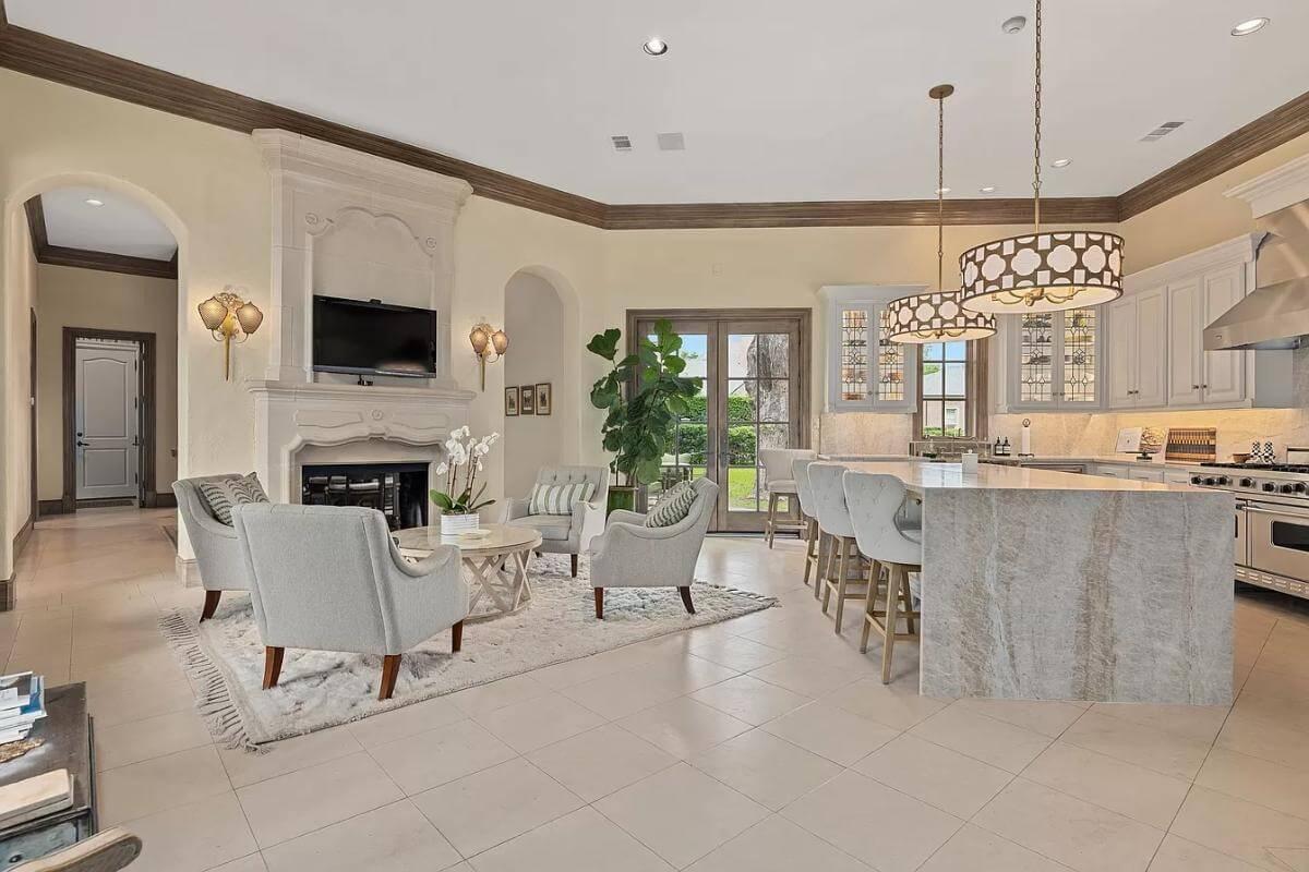 Take In the Marble Kitchen Island and Ornate Fireplace in This Open Living Space