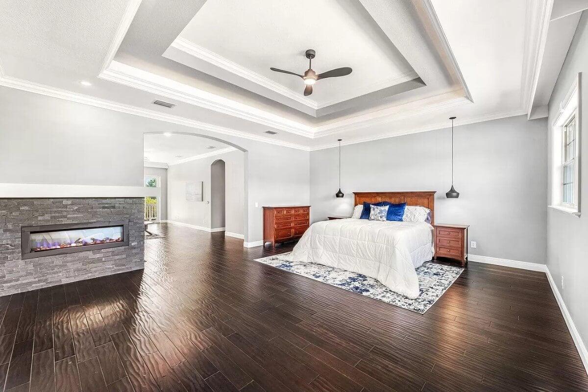 Master Suite with Striking Tray Ceiling and Stone Fireplace