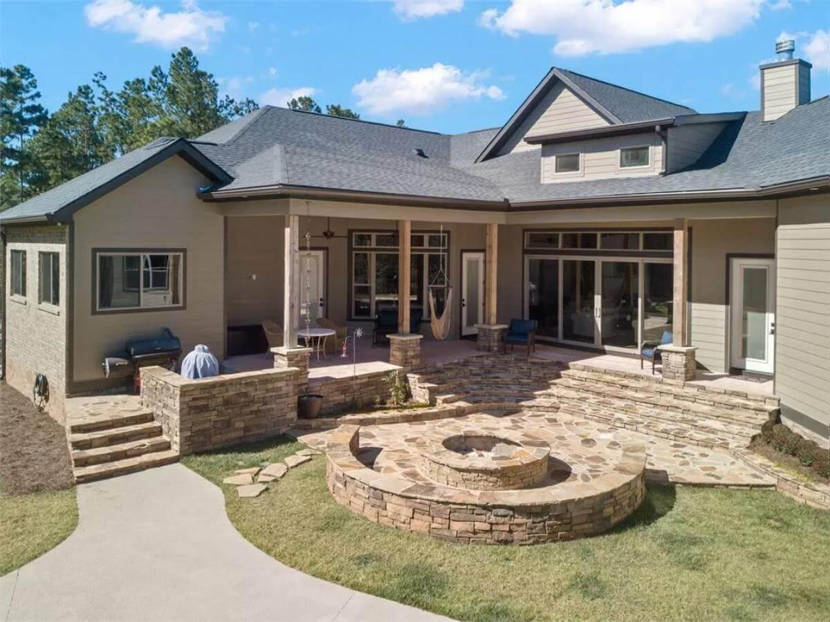 Check Out This Expansive Patio With Its Stone Fire Pit