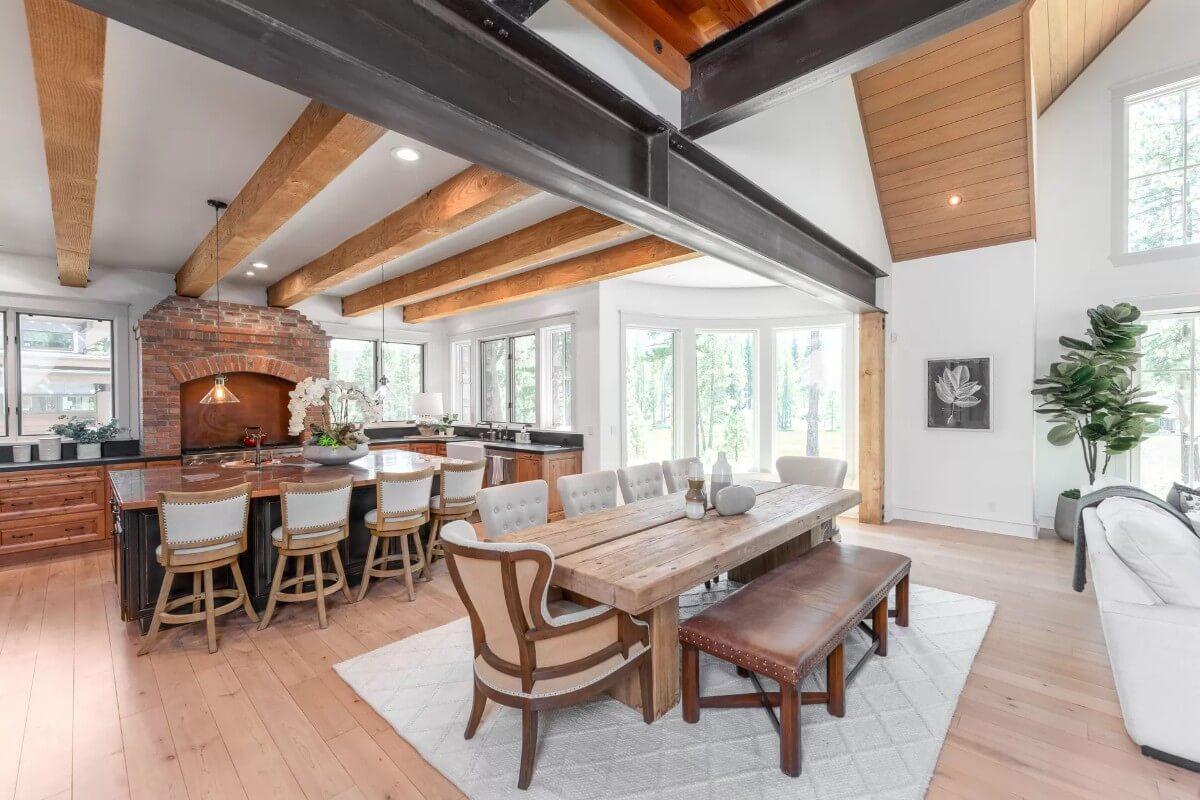 Check Out the Wooden Beams and Brick Accent in This Open Kitchen and Dining Area