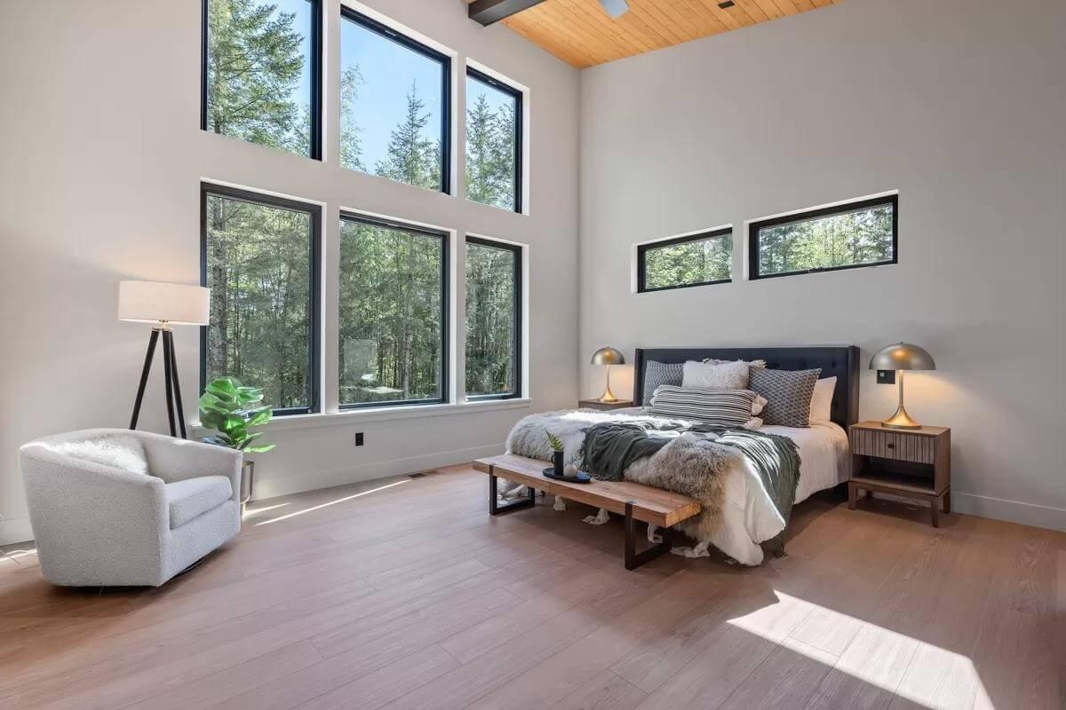 Admire the Tall Windows and Wood Accents in This Serene Bedroom