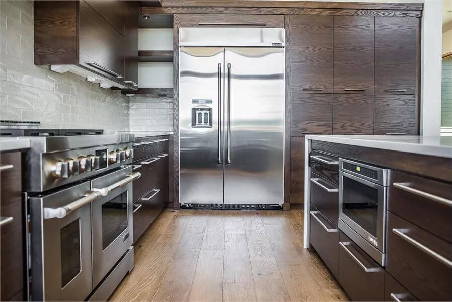 Sleek Stainless Steel Appliances Paired with Rich Wood Cabinets in This Modern Kitchen