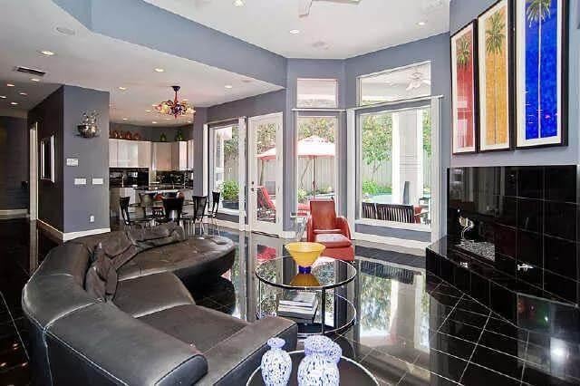 Expansive Living Area with Sleek Black Flooring and Vibrant Art