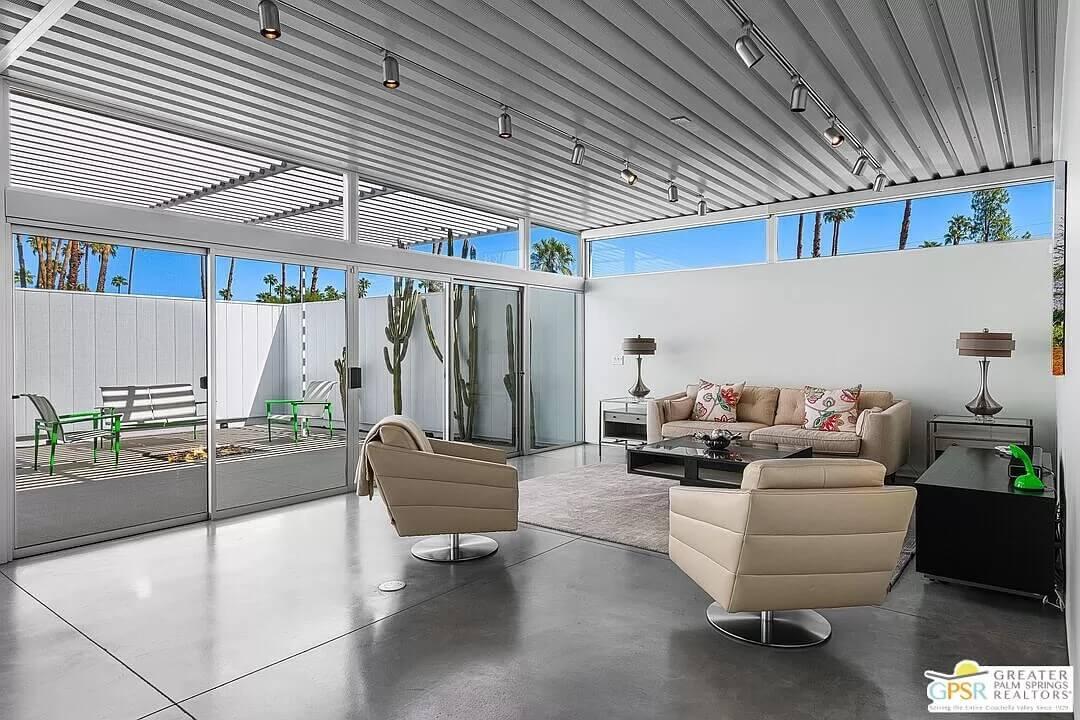 Sunlit Living Room with Floor-to-Ceiling Glass and Cacti Views