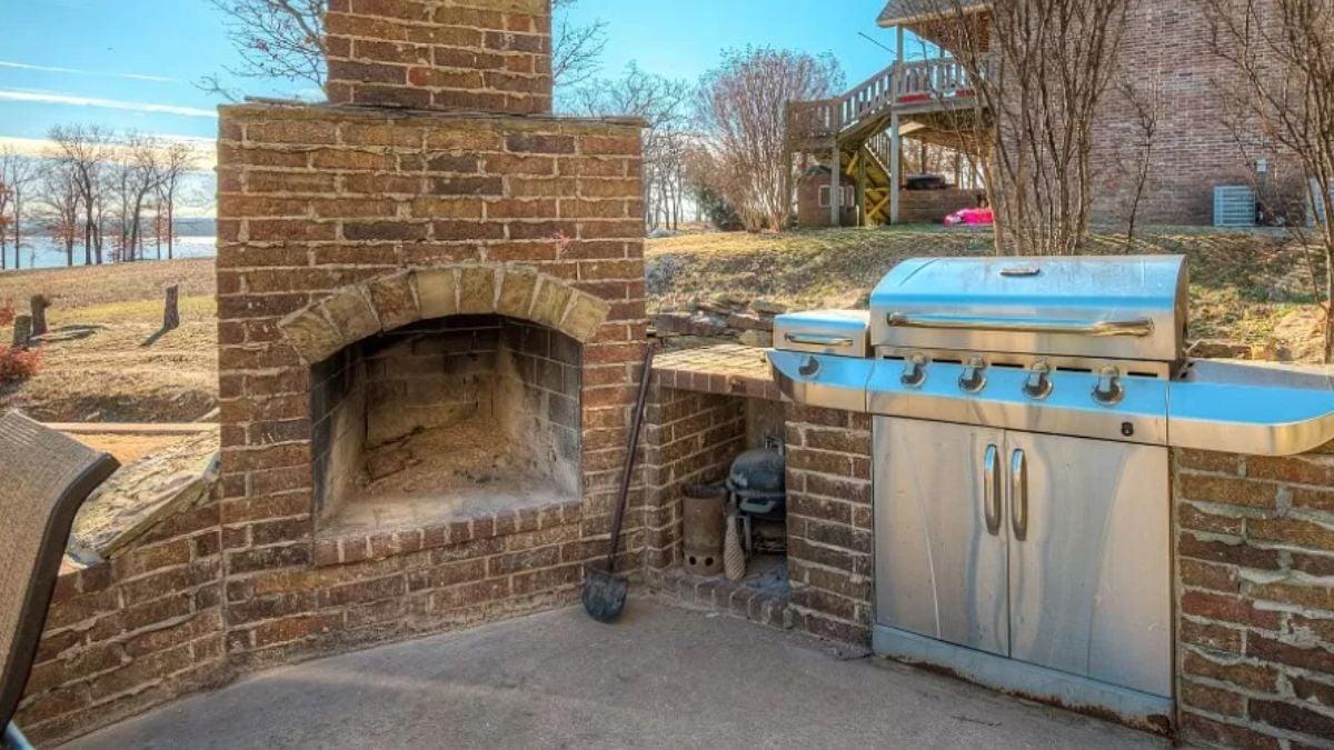 Enjoy an Outdoor Patio with Brick Fireplace and Modern Grill