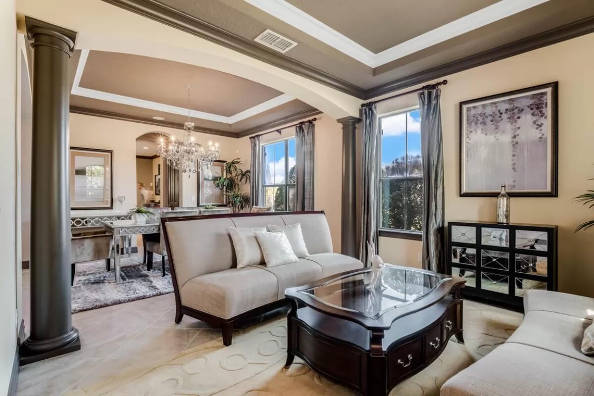 Formal Living Room With Striking Columns and Chandeliers