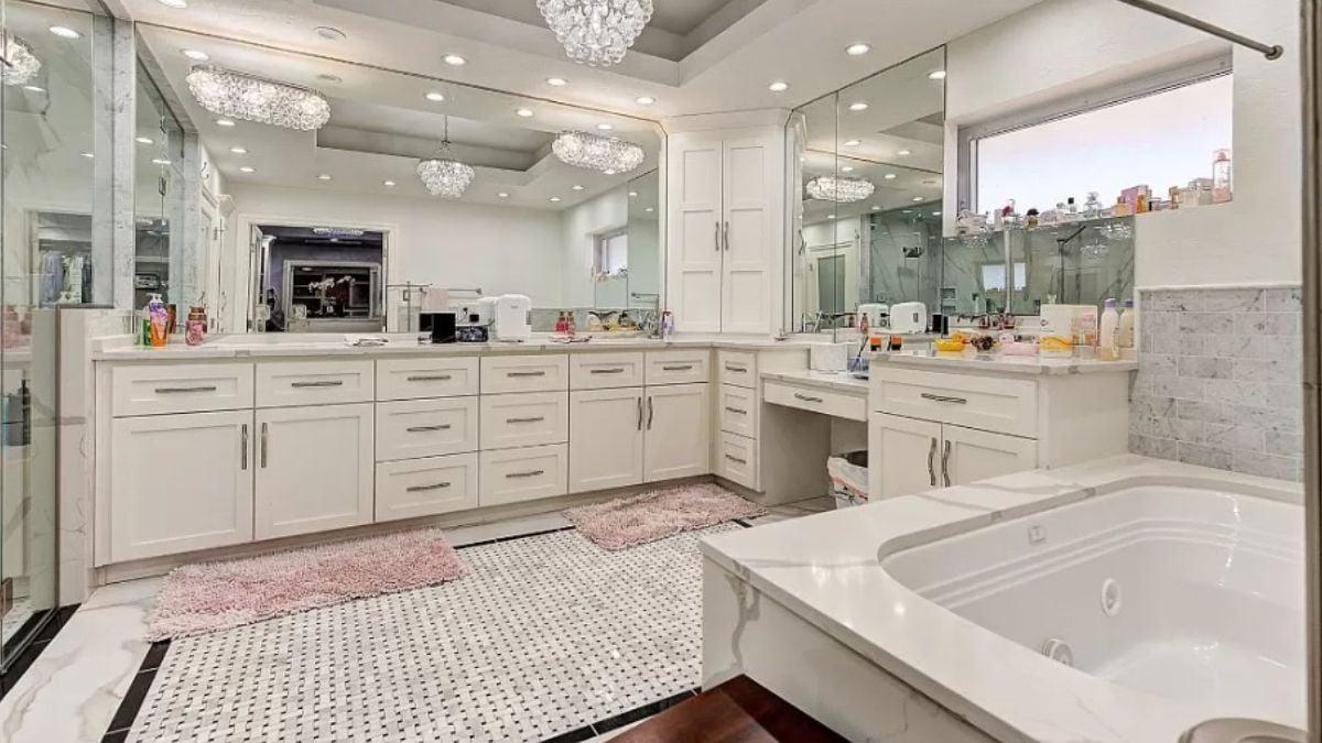 Large Vanity Area with Crystal Chandeliers in This Spacious Bathroom