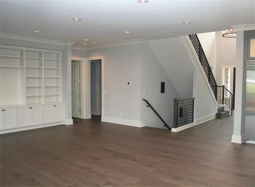 Open Living Space with Sleek Built-in Shelving and Modern Staircase