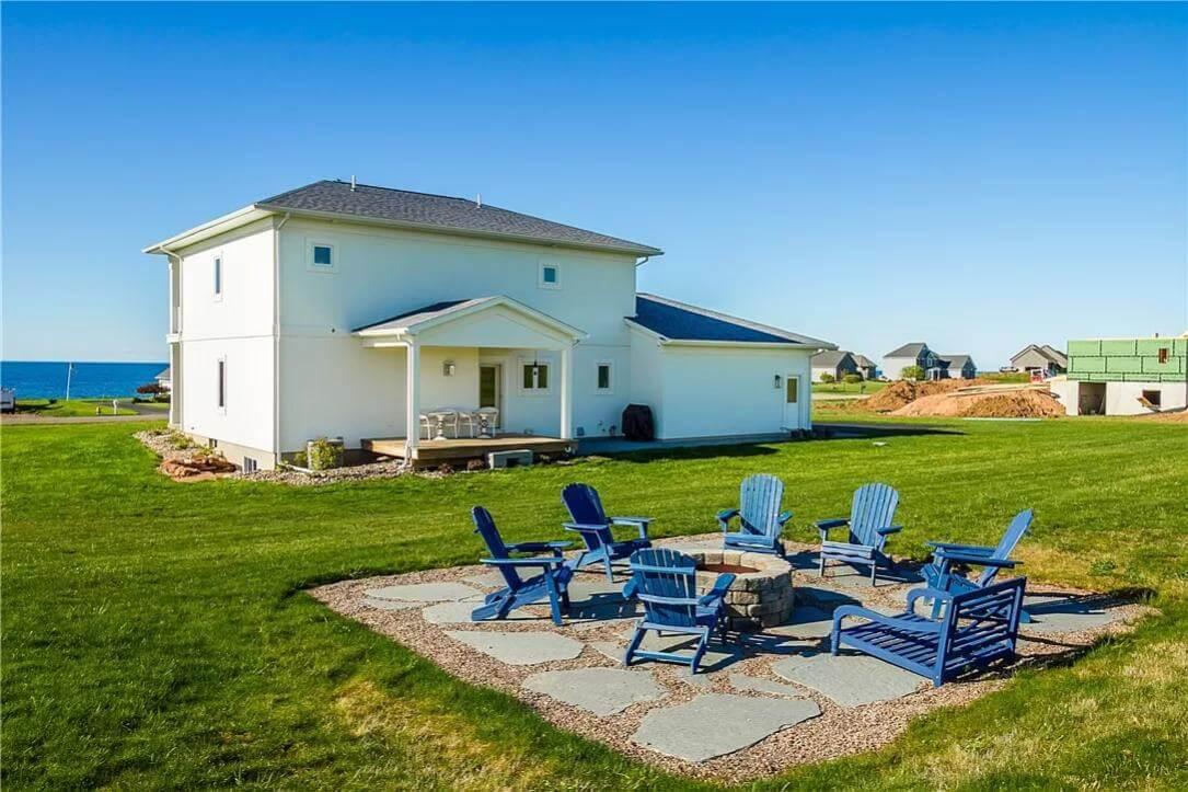 Enjoy the Fire Pit and Adirondack Chairs in This Spacious Backyard