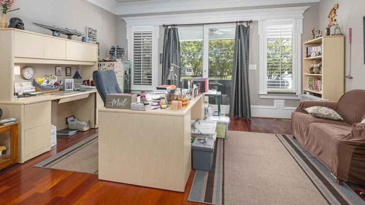 Spacious Home Office with Wall-to-Wall Shelving and Hardwood Floors