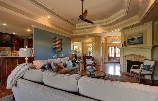 Warm Living Room with a Sleek Ceiling Fan and Ornate Fireplace