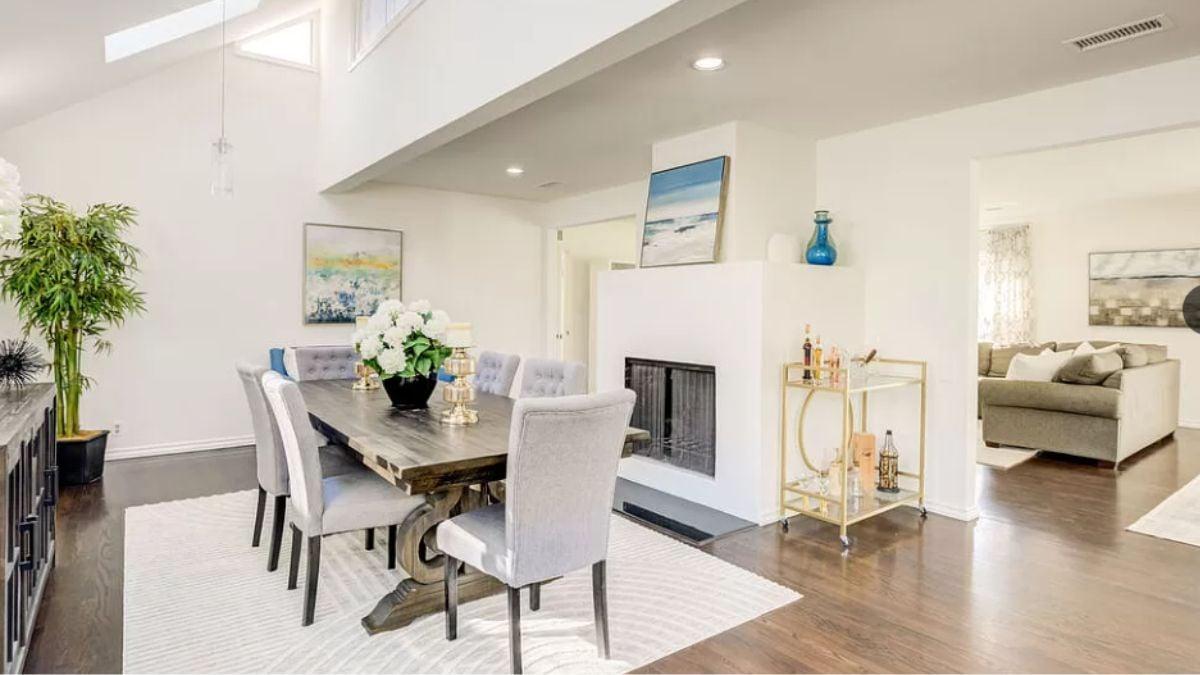 Sophisticated Dining Space with Skylights and a Functional Double-Sided Fireplace