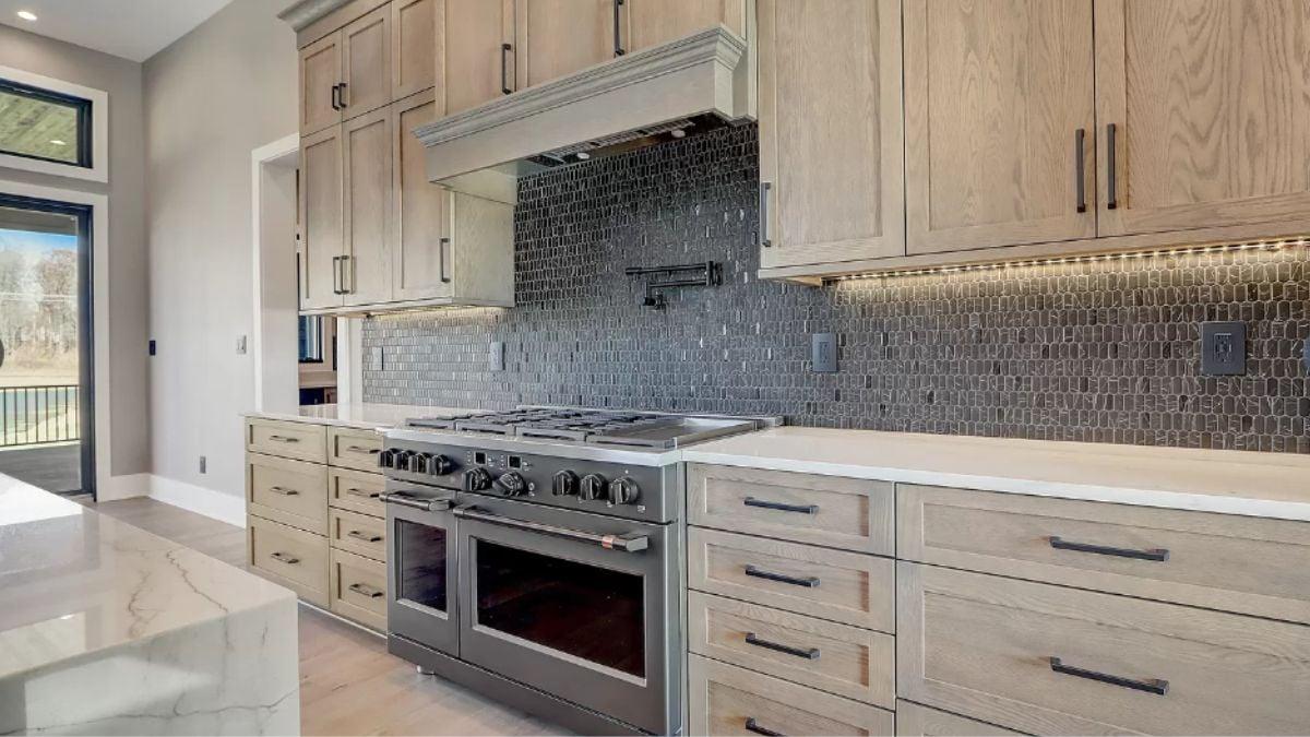Admire the Textured Backsplash and Modern Under-Cabinet Lighting