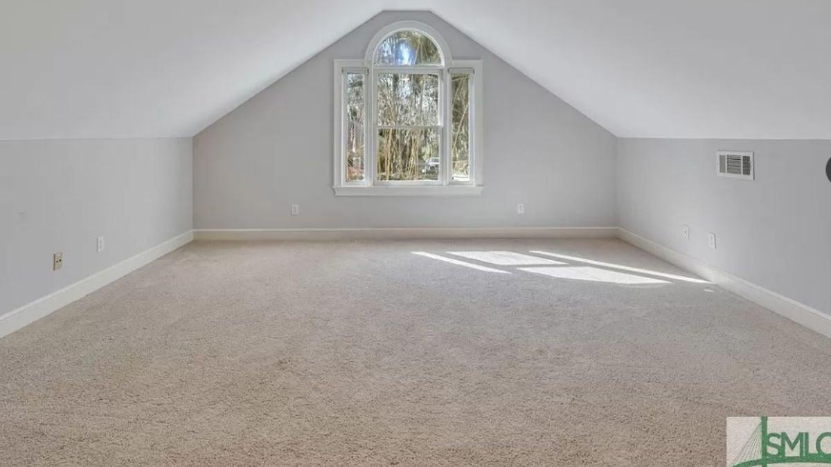 Expansive Attic Room with Arched Window Detail
