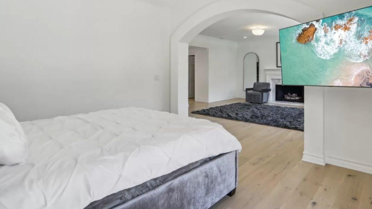Cozy Bedroom Retreat Featuring an Archway Connecting to a Relaxation Space