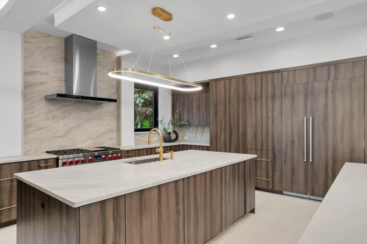Explore This Sleek Kitchen with a Dramatic Waterfall Island and Gold Accents