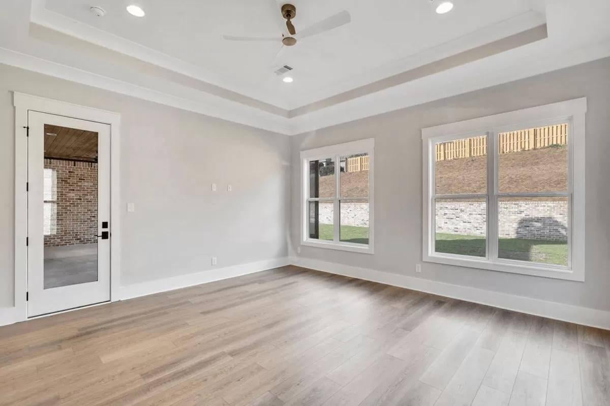 Check Out the Tray Ceiling and Modern Fan in This Bright Room