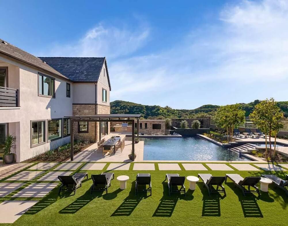 Admire the Expansive Pool and Sleek Pergola in This Outdoor Retreat