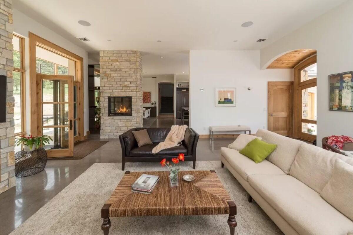 Notice the Dual-Sided Stone Fireplace Adding Warmth to Two Spaces