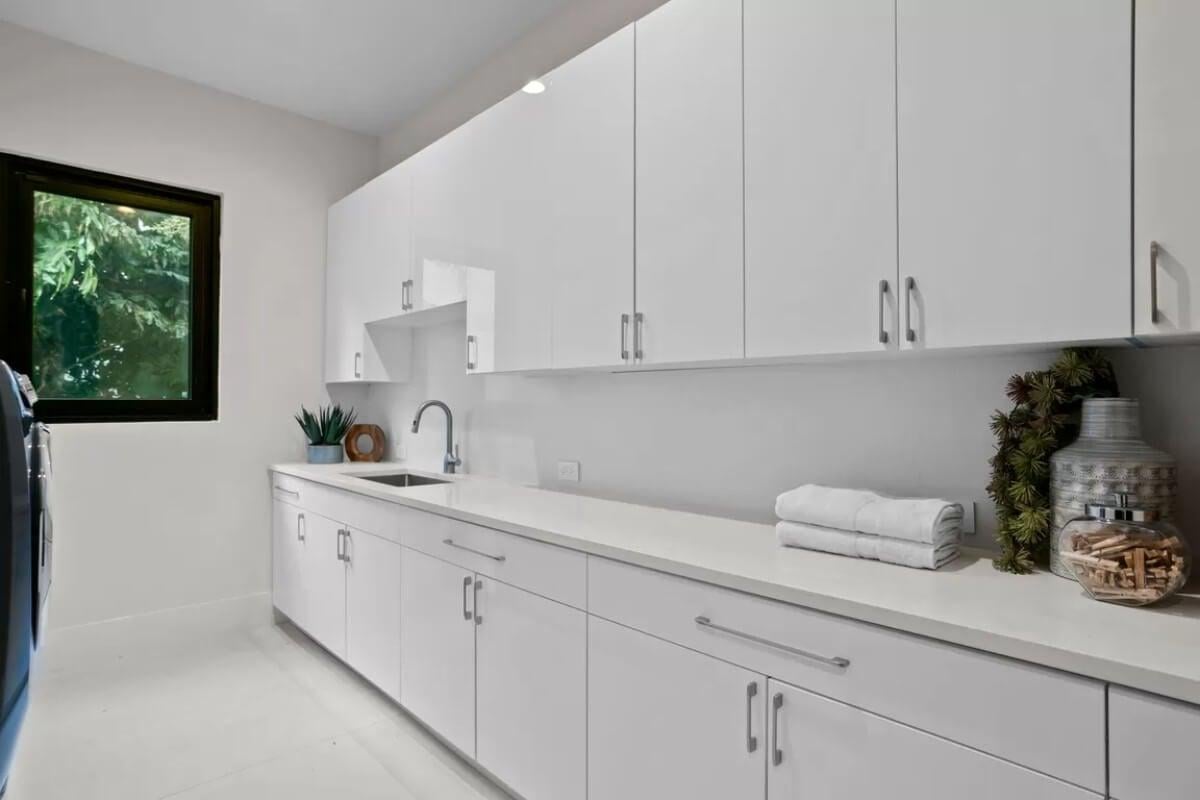 Sleek Laundry Room with Streamlined Cabinetry and Thoughtful Decor