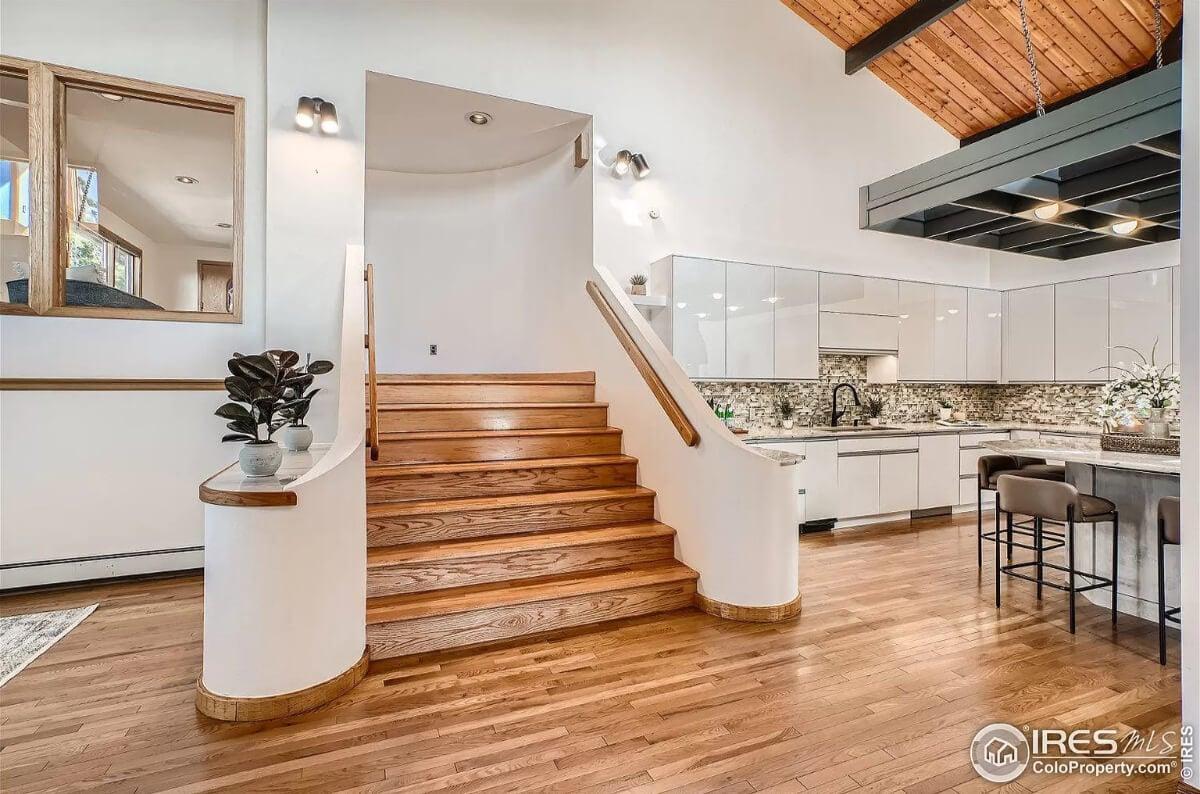 Notice the Curved Staircase Leading to a Modern Kitchen