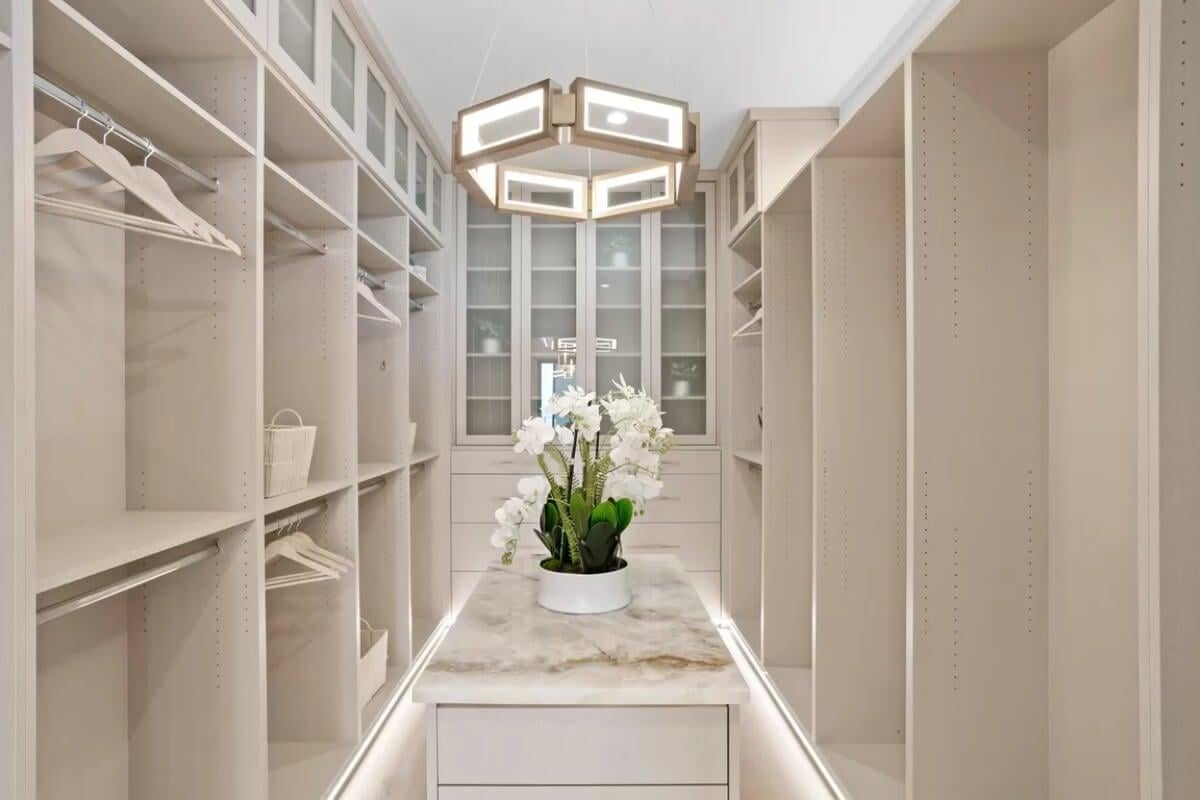 Explore This Elegant Walk-In Closet with Marble Island and Geometric Lighting