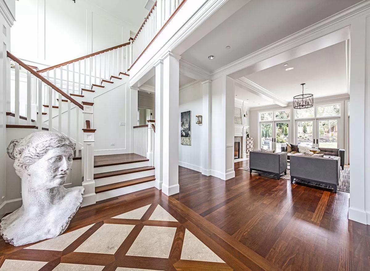 Grand Entrance With Elegant Sculpture and Sweeping Staircase