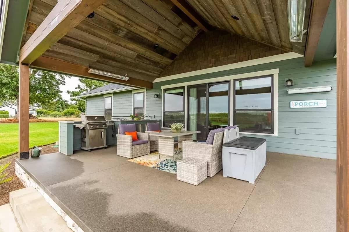 Covered Backyard Porch with Rustic Beam and Cozy Seating Area