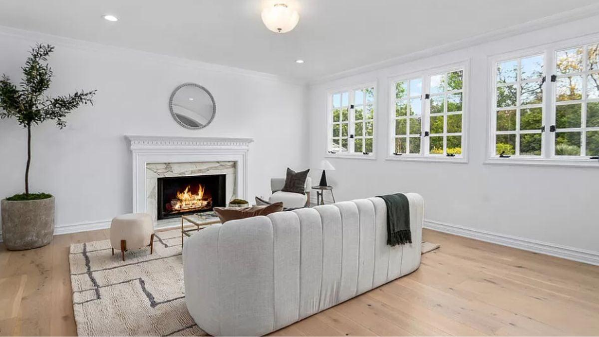 Look at This Living Room with Expansive Windows and a Marble Fireplace